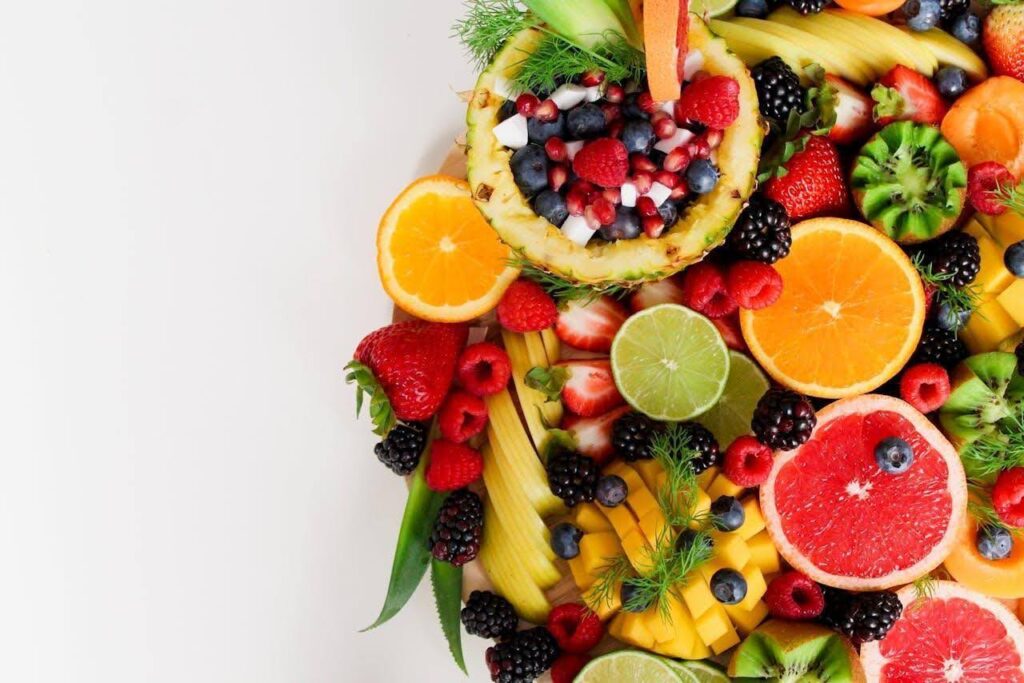 A plate of sliced fruits and berries.